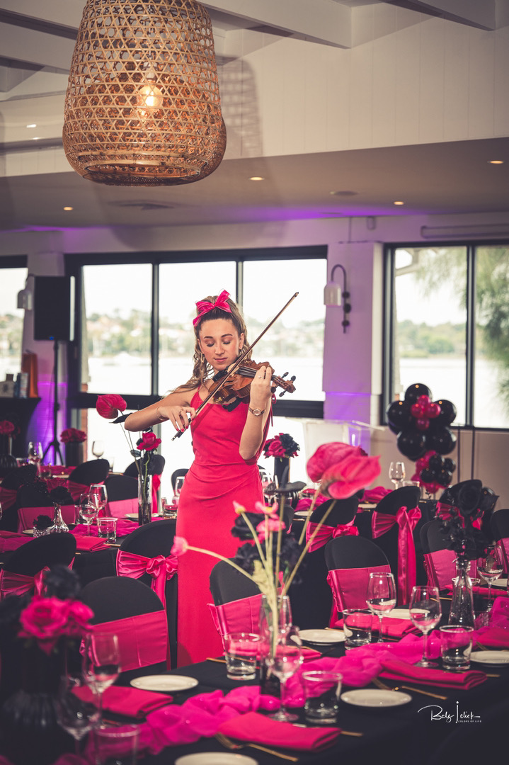 Tali playing violin in a pink themed party